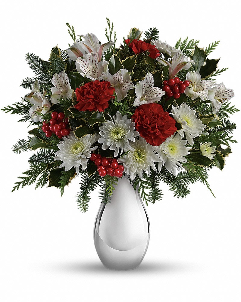 Teleflora's Silver And Snowflakes Bouquet - Brighten any winter's day with this festive array of crimson carnations and winter white alstroemeria. Hand-delivered in a shimmering silver vase, it's a fresh, fabulous way to send your holiday best. Red carnations, white alstroemeria and white cushion chrysanthemums are arranged with variegated holly, flat cedar, noble fir and red berries. Delivered in a beautiful Silver Reflections vase.