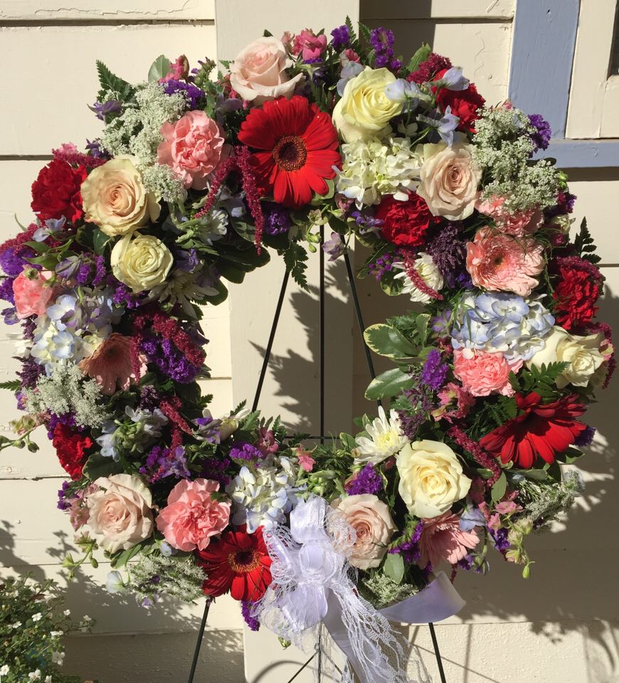 Loving Tribute Loving Tribute - Wreath with jewel tones a mixture of roses, daisies, hydrangea, Amaranths.