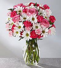 Eckert Florist's FTD Sweet Surprises Bouquet With Roses - The FTD Sweet Surprises Bouquet is an absolutely charming way to send your warmest sentiments. Spray roses, pink mini carnations, white traditional daisies and lush greens are sweetly situated in a classic clear glass vase to create a bouquet that will delight your special recipient at every turn.