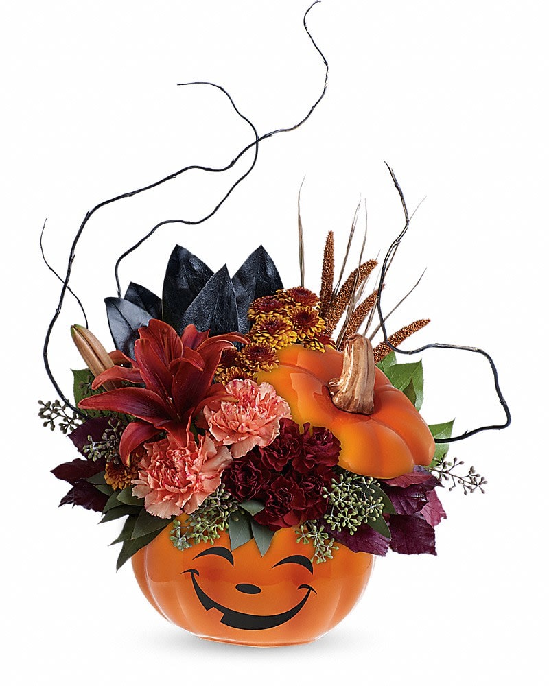 Teleflora's Halloween Magic Bouquet - What a &quot;boo&quot;-tiful way to wish them a Happy Halloween! This spirited mix of lilies, carnations, mums and fun fall accents is hand-delivered in a delightful ceramic pumpkin, the perfect Halloween candy jar! This magical bouquet features rust-colored asiatic lilies, orange carnations, miniature maroon carnations, brown button spray chrysanthemums, magnolia leaves, burgundy copper beech, seeded eucalyptus, lemon leaf, curly willow and dried brown china millet. Delivered in a Halloween Magic Pumpkin container.