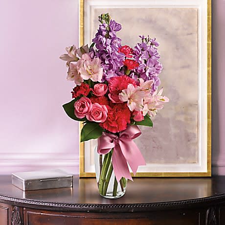 Jumping for Joy - Lush lavender stock, pale pink alstroemeria, hot pink spray roses and mini carnations are delivered in a traditional glass vase adorned with a pink ribbon.