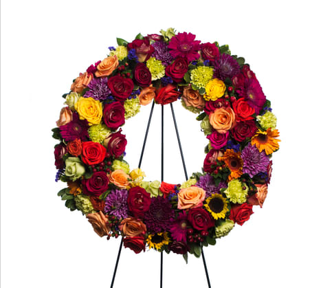 24&quot; Bright Blooms Wreath - Assorted flowers perfectly arranged in the form of a wreath, to create a beautiful way to display your sincere sentiments Each wreath is unique and is comprised of a different combination of flower varieties. The picture shows just one example. This arrangement can be made in different color palettes. 