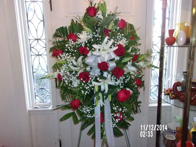 Red and white simplicity - Standing or easel spray done in reds and whites. Roses and lilies make up this elegant spray.