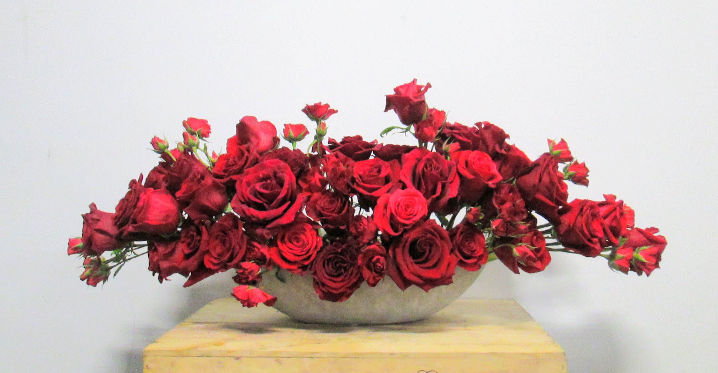 Nothing but Red Roses Nothing but Red Roses - Modern stone boat brimming with a variety of shades and sizes of red roses.