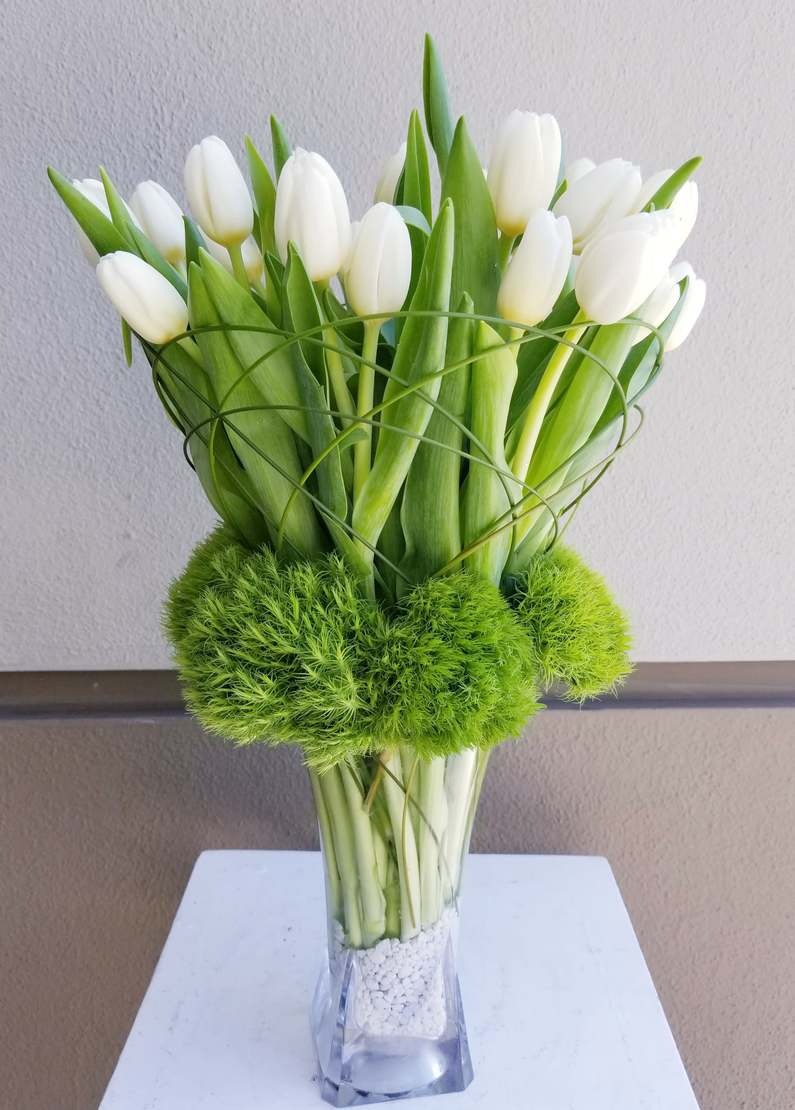 Ice Tulips - 20 stems of white tulips designed in a clear vase with dianthus and grass decor.