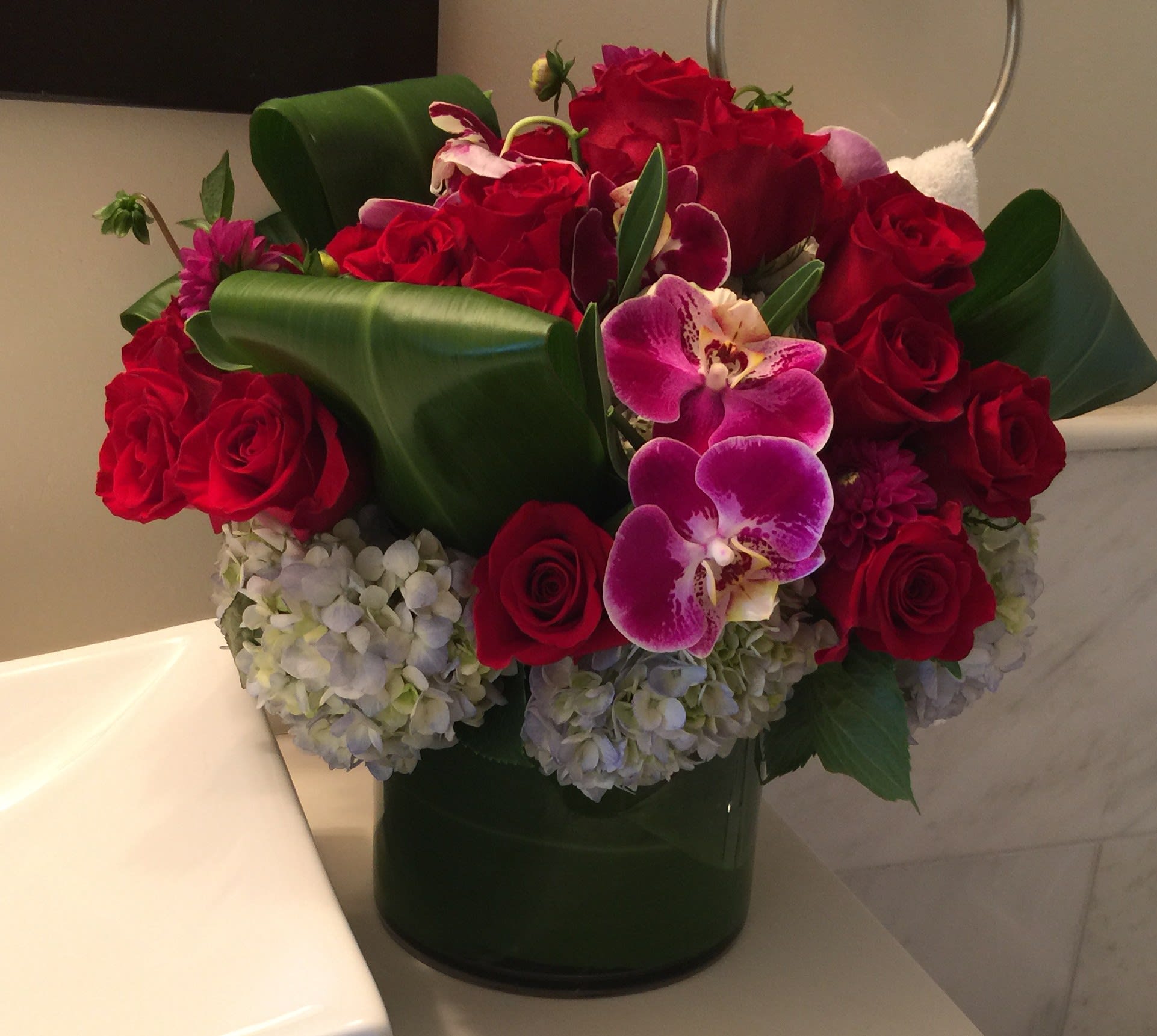  Red Roses and Orchids - 2 doz red roses in a low full vases with pink orchids and ti leaves. 3 doz and  4 doz