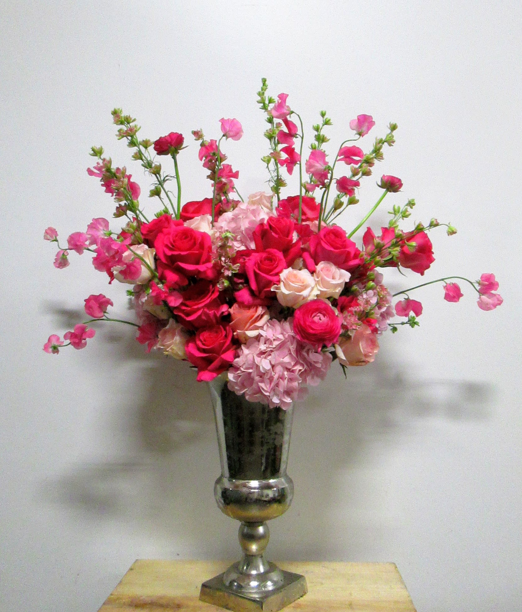 Hot Pink Passion Hot Pink Passion - Traditional upright with hot pink roses, Japanese Sweet Pea, hydrangea, ranunculas and larkspur