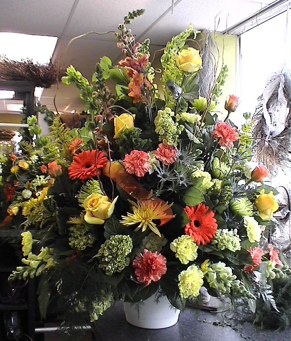 Harmony Sympathy Urn - Tribute urn of beautiful bright garden flowers of Gerber Daisies, Roses, Snapdragons, Stock, Carnations and more. Overhead Lid Spray also available to match. Flower varieties may vary depending on seasonal availability.