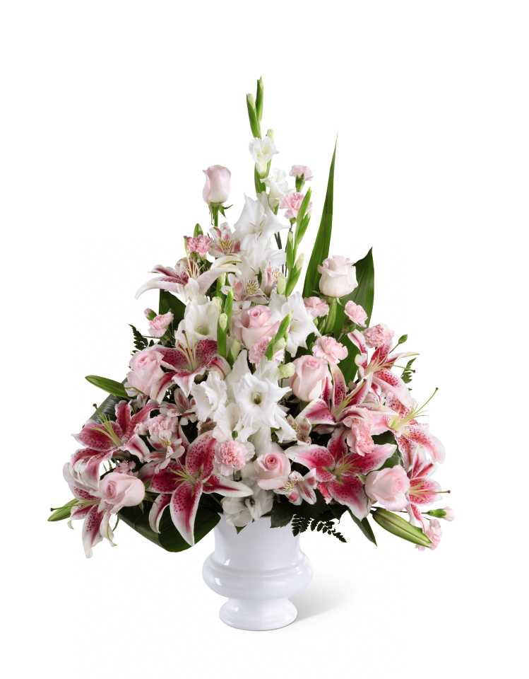 Precious Peace Arrangement - The Precious Peace Arrangement is an exquisite display of serene wishes and grace. Soft pink roses, alstroemeria and mini carnations are arranged amongst dazzling Stargazer lilies and white gladiolus, gorgeously accented with lush greens. Perfectly situated in a white designer urn, this stunning arrangement will add to the beauty and elegance of the service or memorial.