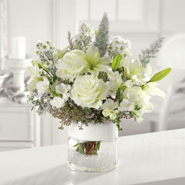 Silent Night Silent Night - Snowy white roses, lilies, freesia and mixed greens come together in a glass cylinder vase to bring a sense calm amid the holiday hustle and bustle. Flowers and similar colors