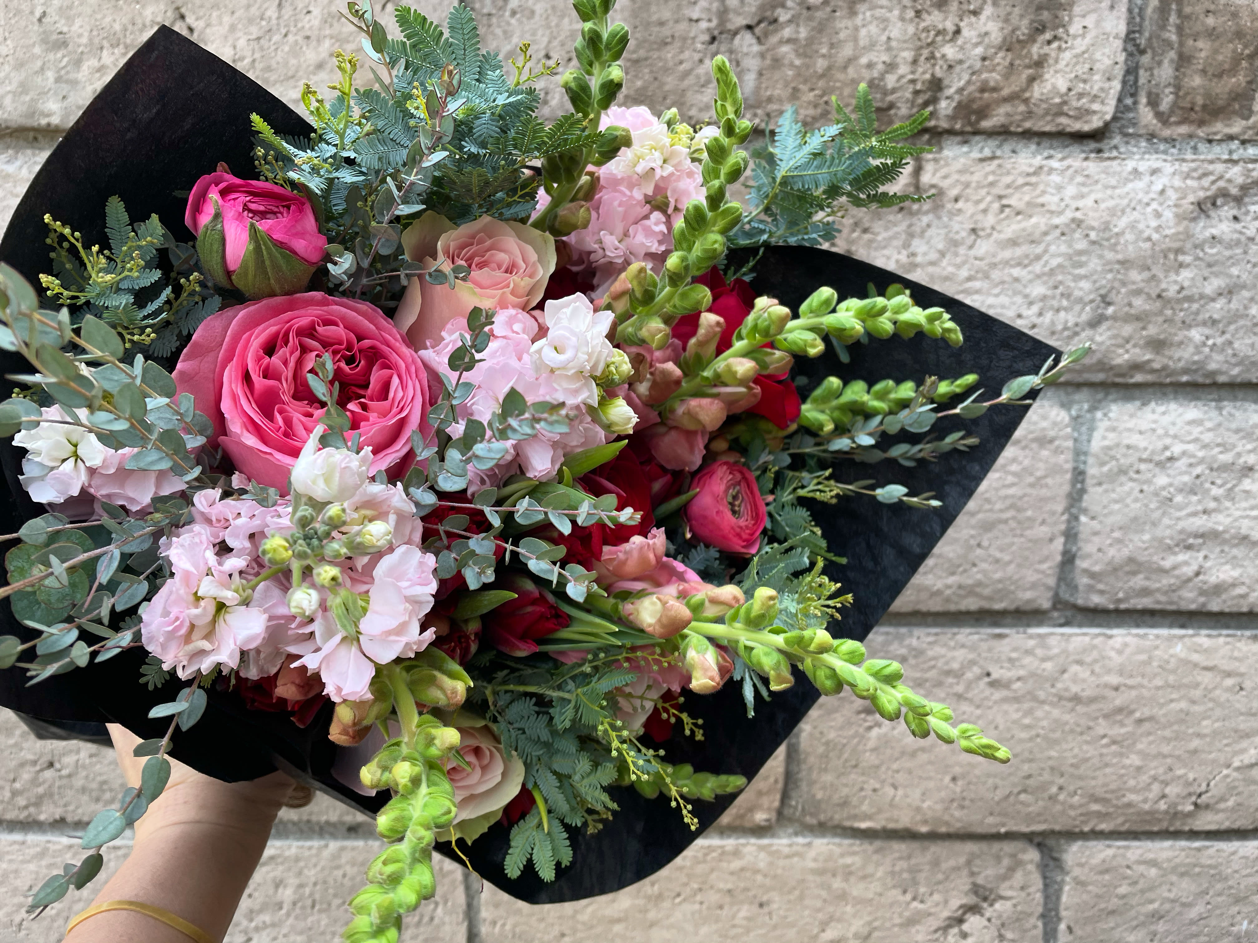 Fade Into You - A perfect curated bouquet of romantic and pretty pinks- Roses, Stock, Snapdragons and Eucalyptus. Delivered wrapped and ready for a vase, this is perfect if they have the perfect one and just need the perfect flowers for it. Every wrap is custom and seasonal and may vary from the photo but will be just as beautiful. 