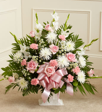 Tribute Pink & White Floor Basket Arrangement Tribute Pink & White Floor Basket Arrangement - When words arenât enough to convey all you feel at this difficult time, let our beautiful floor basket arrangement help you express your feelings perfectly. With pink flowers to symbolize admiration and appreciation for a life well lived and white flowers to symbolize peace and respect, this gathering of fresh roses, snapdragons, carnations and more brings beauty and hope to a difficult time. Floor basket arrangement of fresh pink roses, white spider mums, white snapdragons, pink carnations and more Appropriate for family, friends or business associates to send directly to the funeral home Our florists use only the freshest flowers available, so colors and varieties may vary Large arrangement measures approximately 32"H x 40"L Medium arrangement measures approximately 32"H x 38"L Small arrangement measures approximately 32"H x 32"L