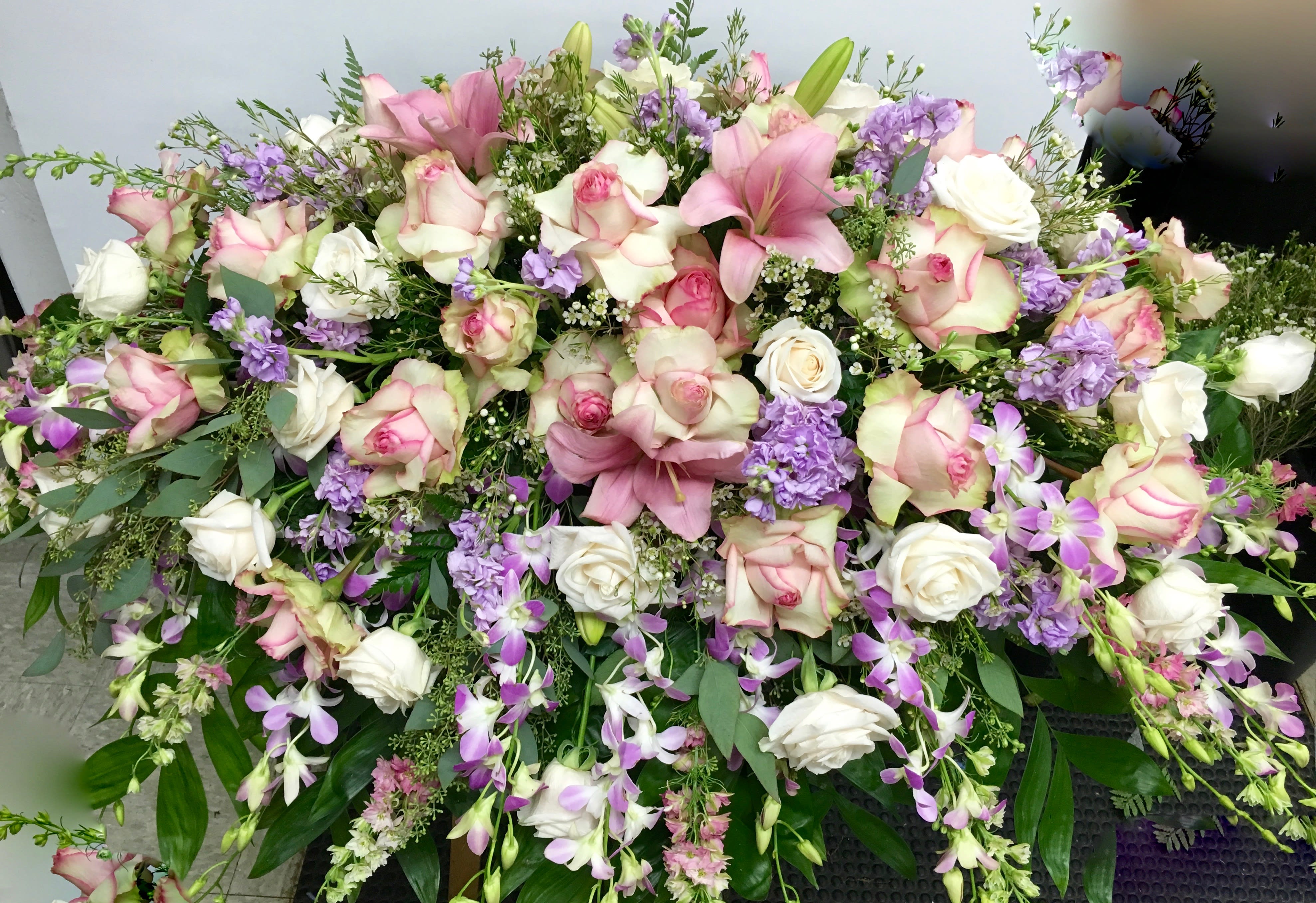 Remembrance Remembrance - In harder times such as these, try to remember the beautiful memories shared between you and the dearly departed with this beautiful, classic spray. Packed with lilies, gorgeous roses, and purple accents.