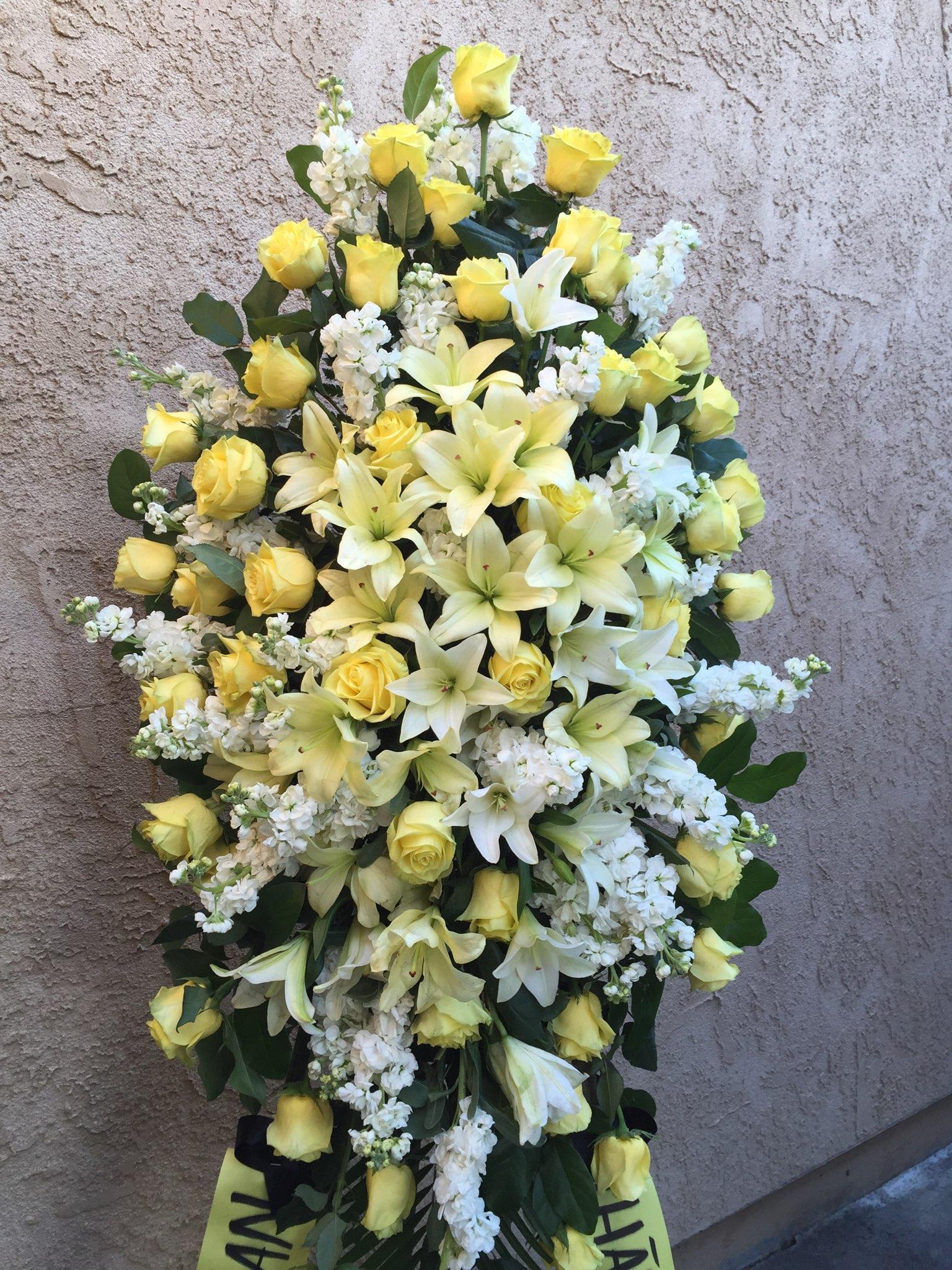 Spray 2 - Standing spray in yellow and white including roses, lilies, stocks, and greens. 
