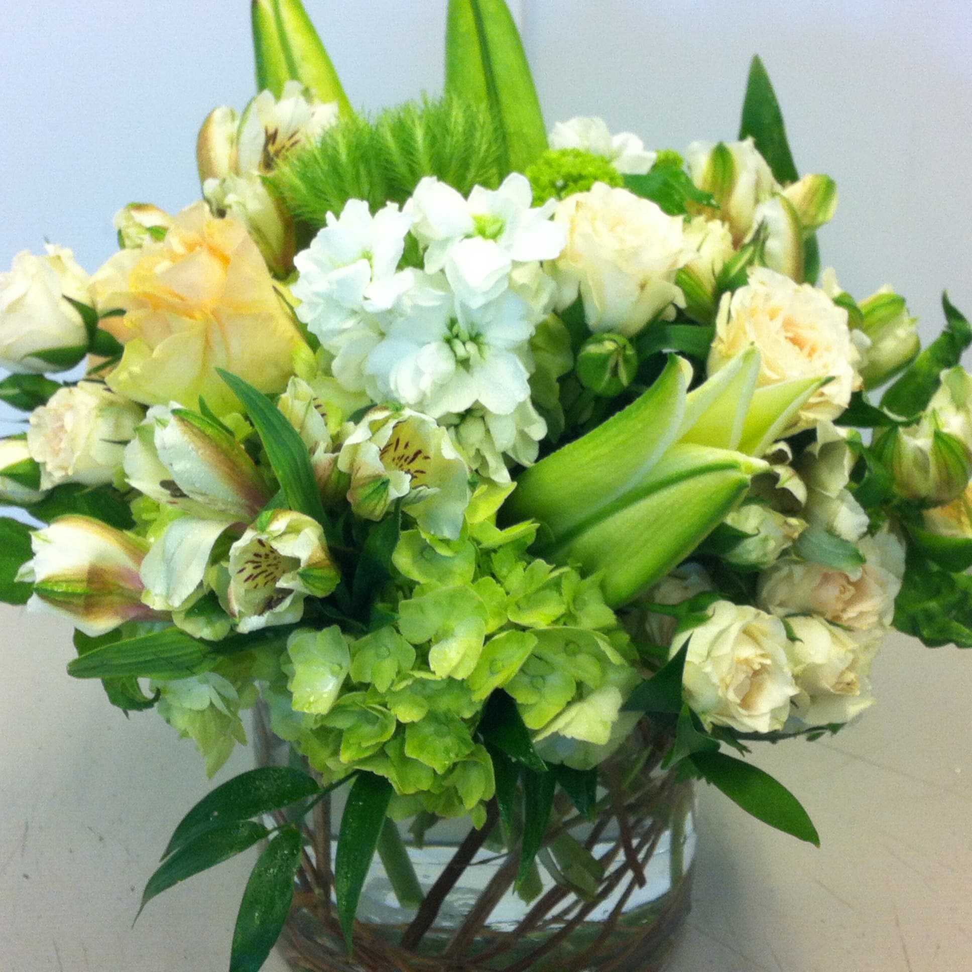 Spring Whites - Spring is a great time to accent that mostly white bouquet with some bright green and some pale pastel color. Lilies, spray roses, hydrangea and other accents. This bouquet will fill out even more as the lilies open.
