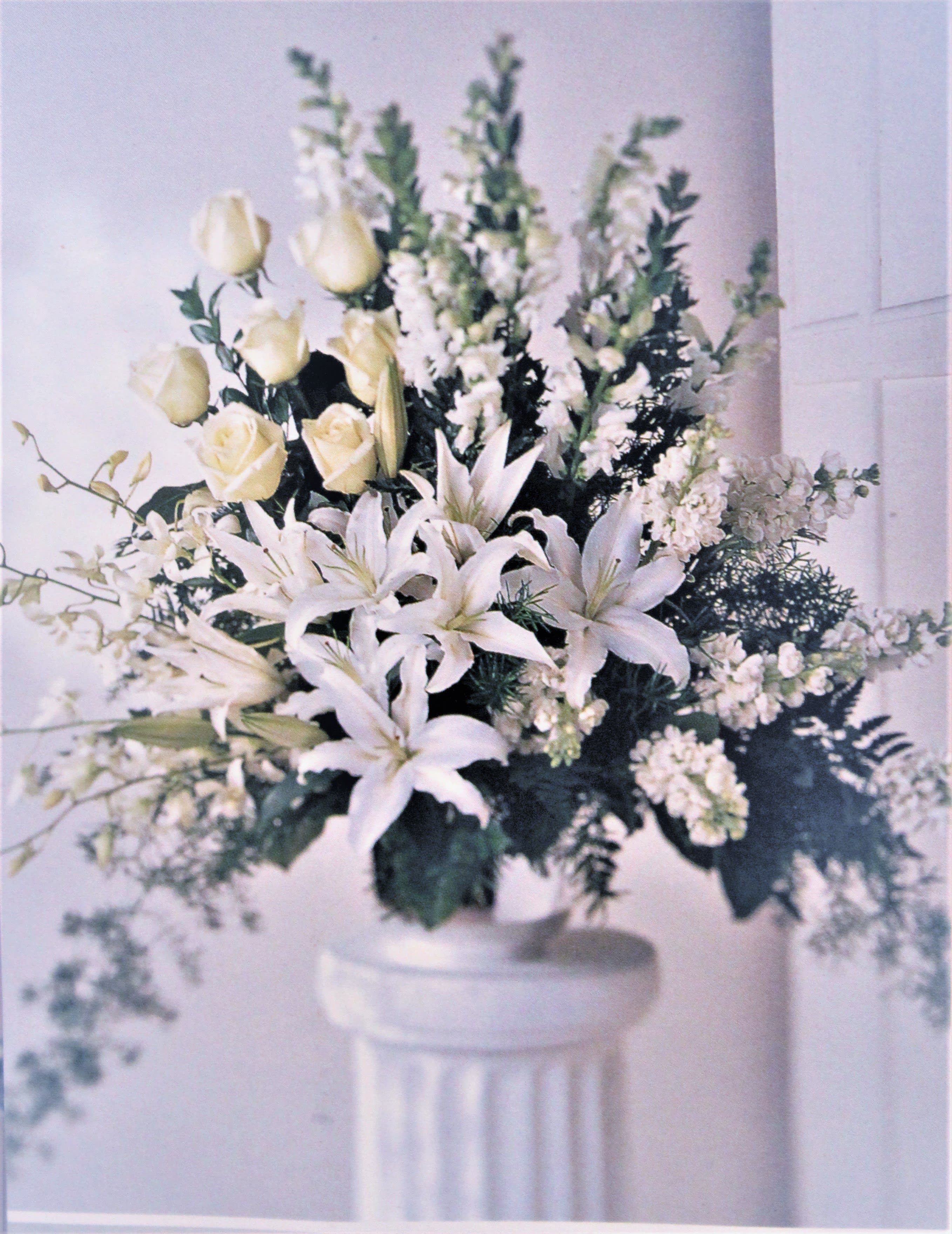 Peaceful Tribute Urn - White orchids, lily's, roses and snap dragons combine together to make a beautiful tribute.