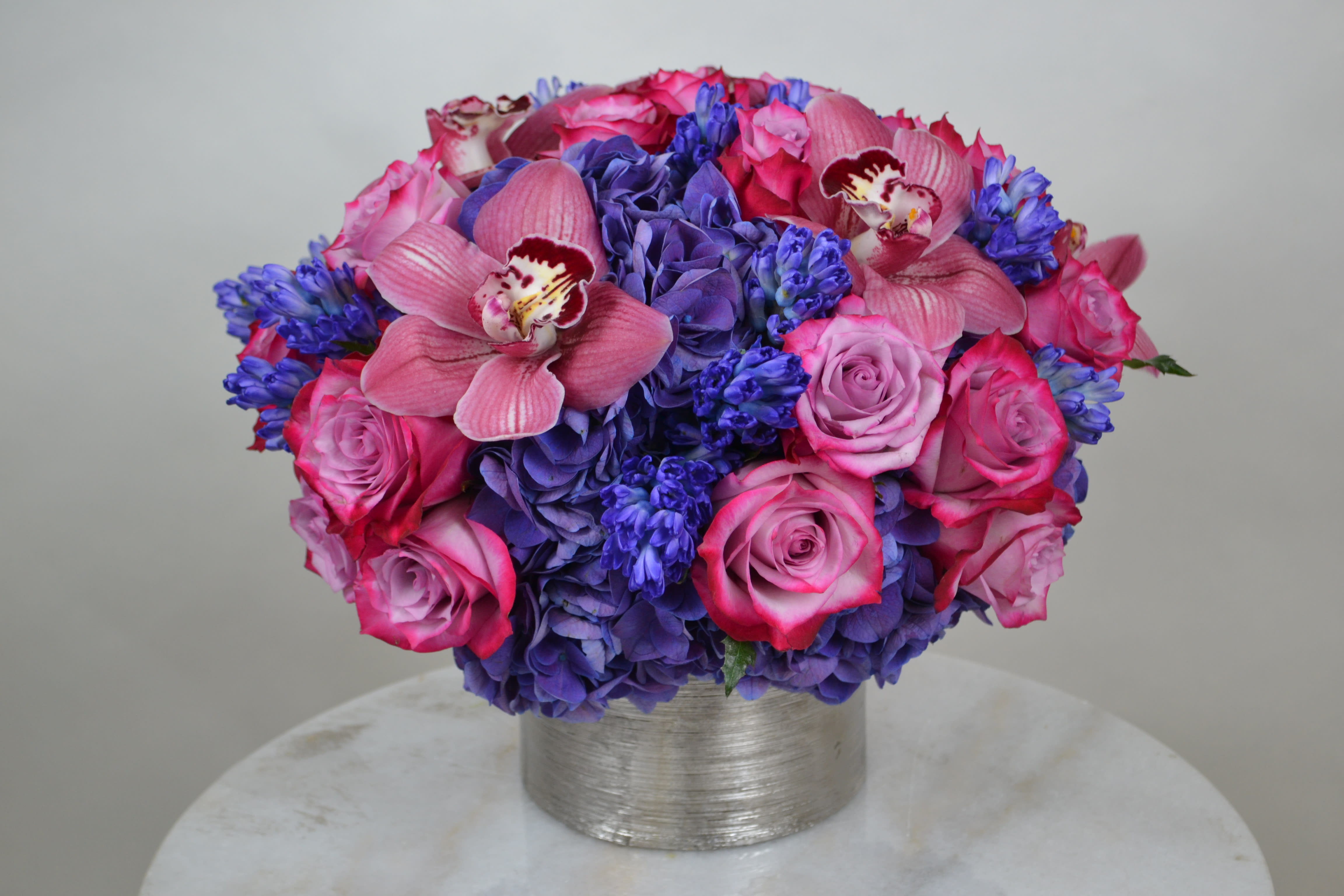 CANDY NIGHT - Who does not fall in love with these beautiful tones, combination of pink and purple roses, cymbidium, hydrangea and hyacinth.
