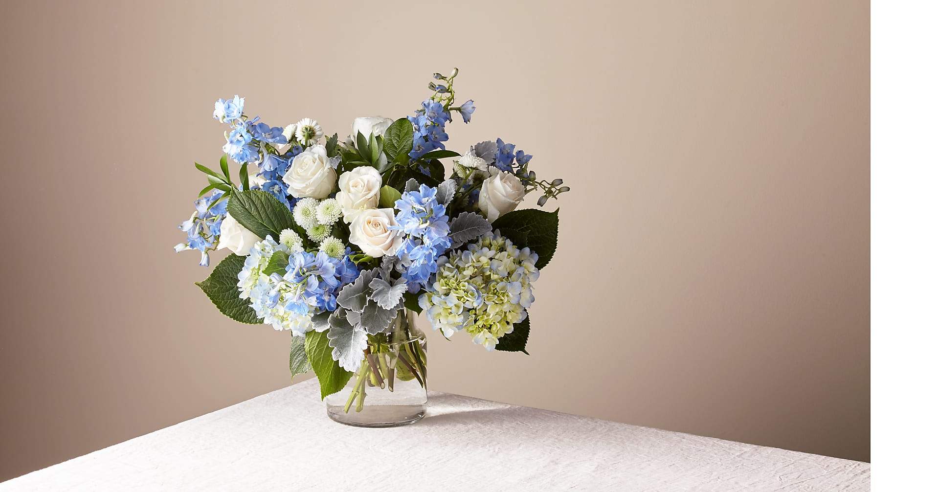 Luxury Clear Skies Bouquet - Let this uplifting arrangement be reminders of the clear skies ahead. Capturing the feeling of hope that a new day brings, this bouquet is composed of voluminous hydrangea blooms and vibrant belladonna delphinium to refresh their mood.