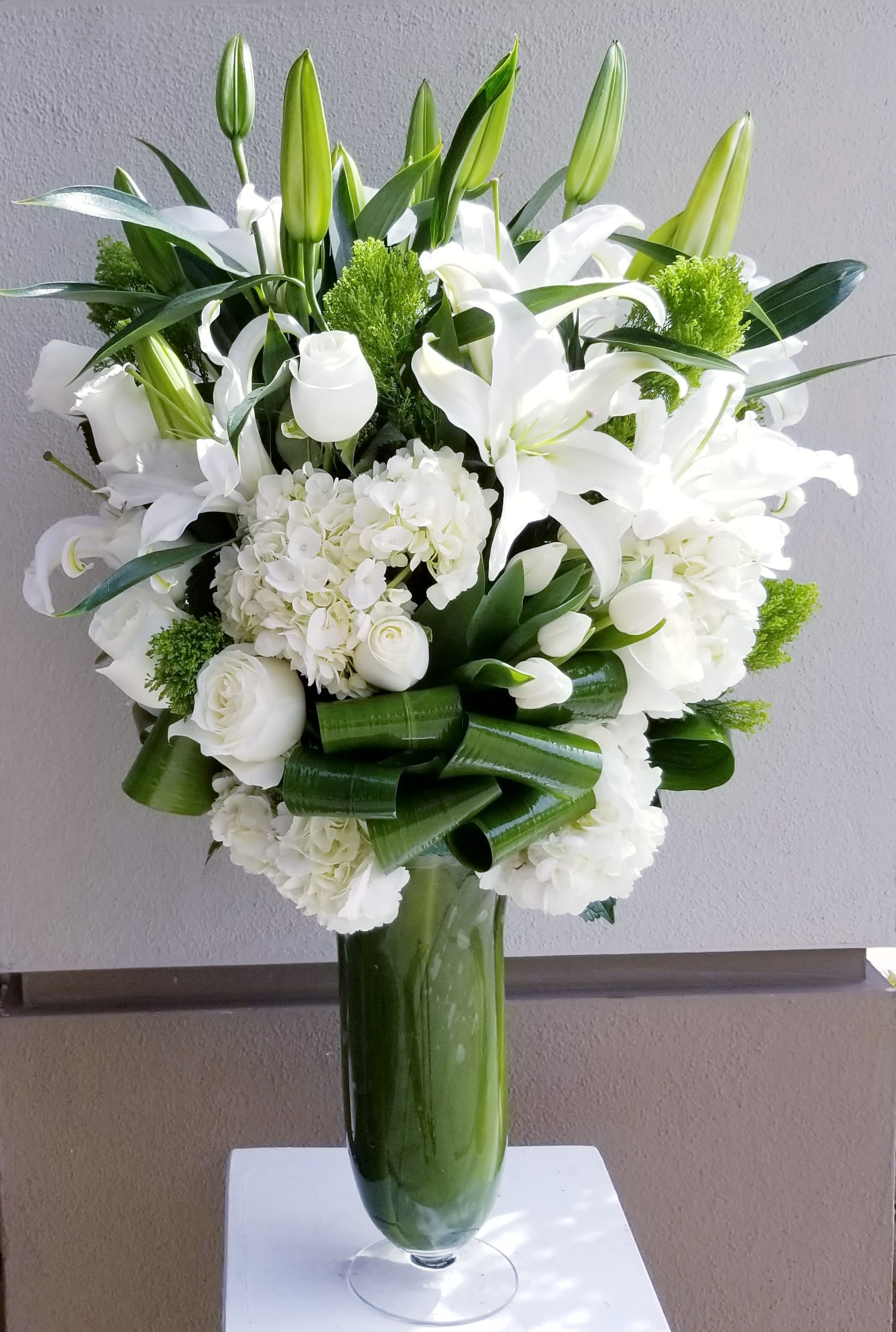 Traditional White - tall arrangement composed all white flowers such as hydrangeas, roses and lilies.