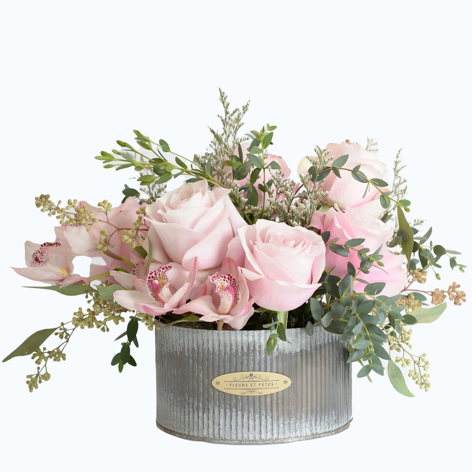 Innocence - Featuring fresh flowers. Light pink roses and cymbidium orchids next to eucalyptus leaves and seeds designed in our rustic ribbed tin vase not only imply innocence but also send a message of appreciation.    *Due to Covid-19, some flowers may not be available. Fleurs et Fetes reserves the right to adjust the flowers and color depending on availability*