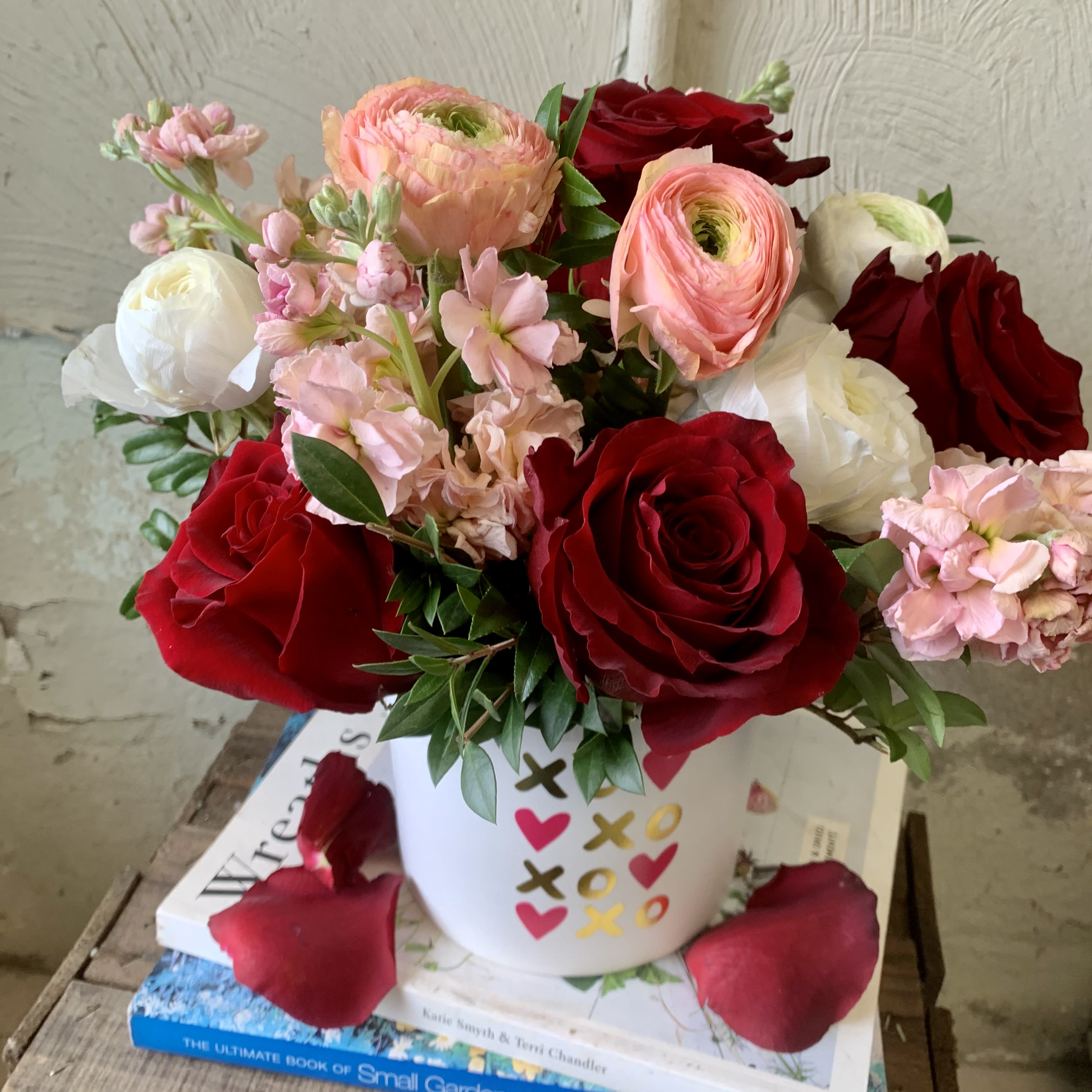 Sparks Fly - This rose combination is flirty, yet romantic. A perfect gift for your first Valentine's Day! Designed with red roses, blush ranunculus and stock in pink shades in white ceramic container.