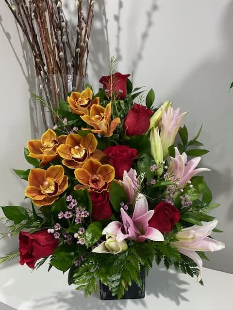 Orchid Oasis Orchid Oasis - Send a gift of modern elegance with this beautiful arrangment up of cymbidium orchids, red roses and Asiatic Lilies with delicate waxflowers and greenery.