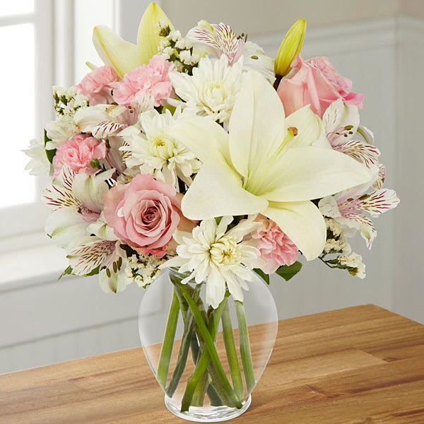 The FTD Pink Dream Bouquet - Classically elegant in a way that will never go out of style this fresh flower arrangement is truly a dream. Pink roses and pink mini carnations are soft and sophisticated amongst a bed of white Asiatic Lilies Peruvian Lilies chrysanthemums and statice perfectly accented with lush greens while situated in a classic clear glass vase. A gorgeous birthday thank you or Mother's Day gift! GOOD bouquet includes 8 stems. Approx. 13&quot;H x 12&quot;W. BETTER bouquet includes 11 stems. Approx. 14&quot;H x 13&quot;W. BEST bouquet includes 13 stems. Approx. 17&quot;H x 15&quot;W.  **Lilies may arrive in bud stage.**