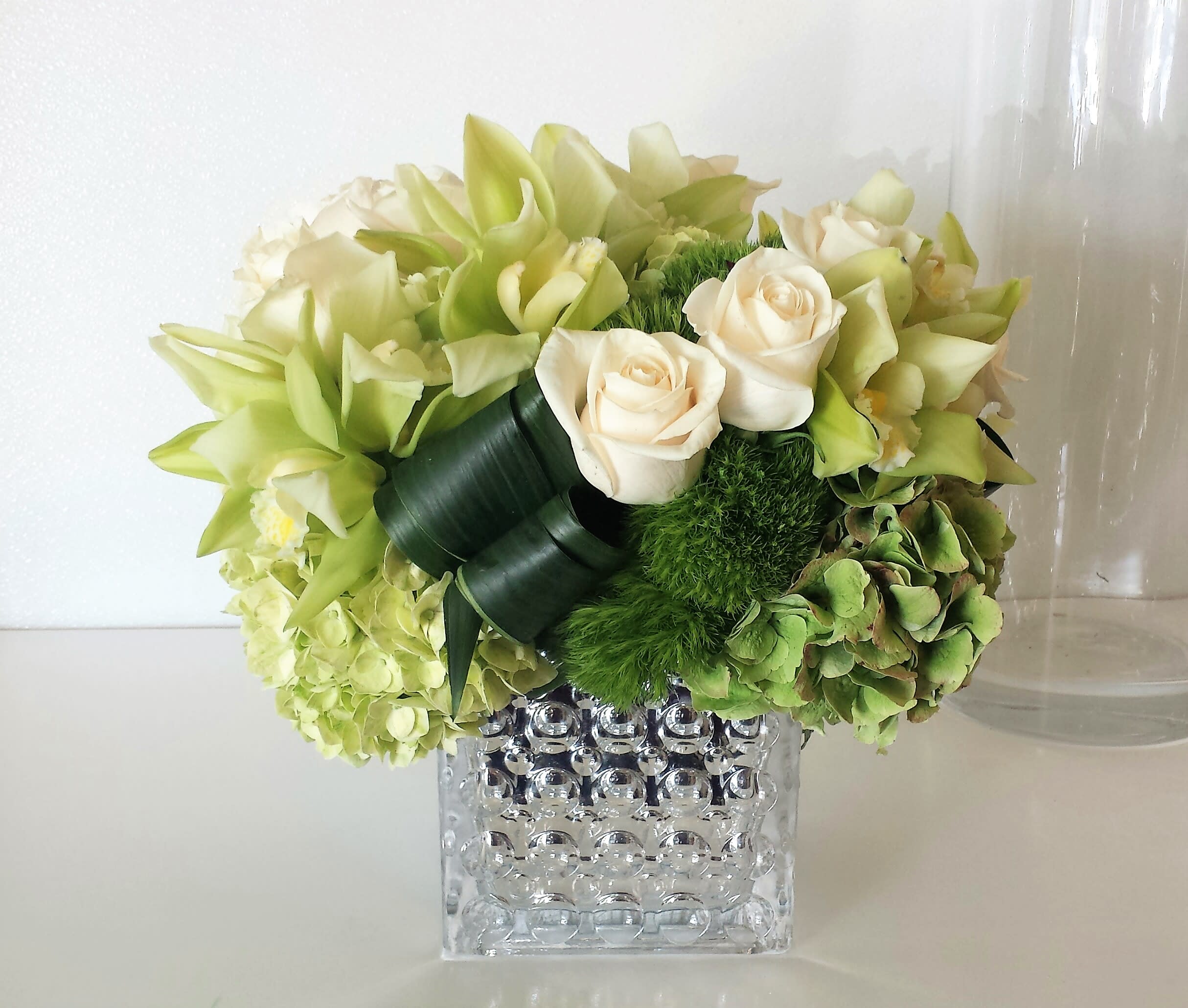 Modern Greens - Modern and elegant arrangement of premium green hydrangea and orchids enhanced with classic white roses