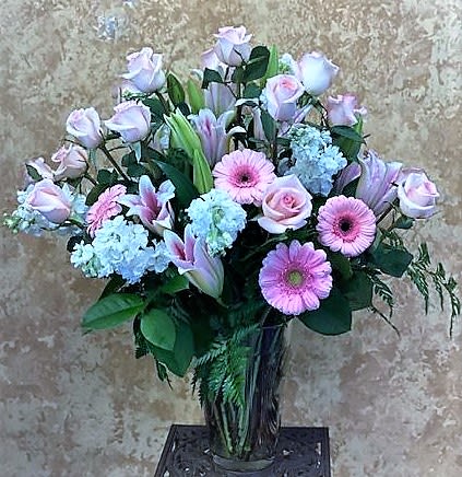 Abundance Overboard  - This arrangement is surley to make a statement filled with beautiful 2 Dozen Pink Roses, Pink Gerber Daisies, Star Gazier Lilies, White Stock and assortment of beautiful greens in a  exta large glass vase.  