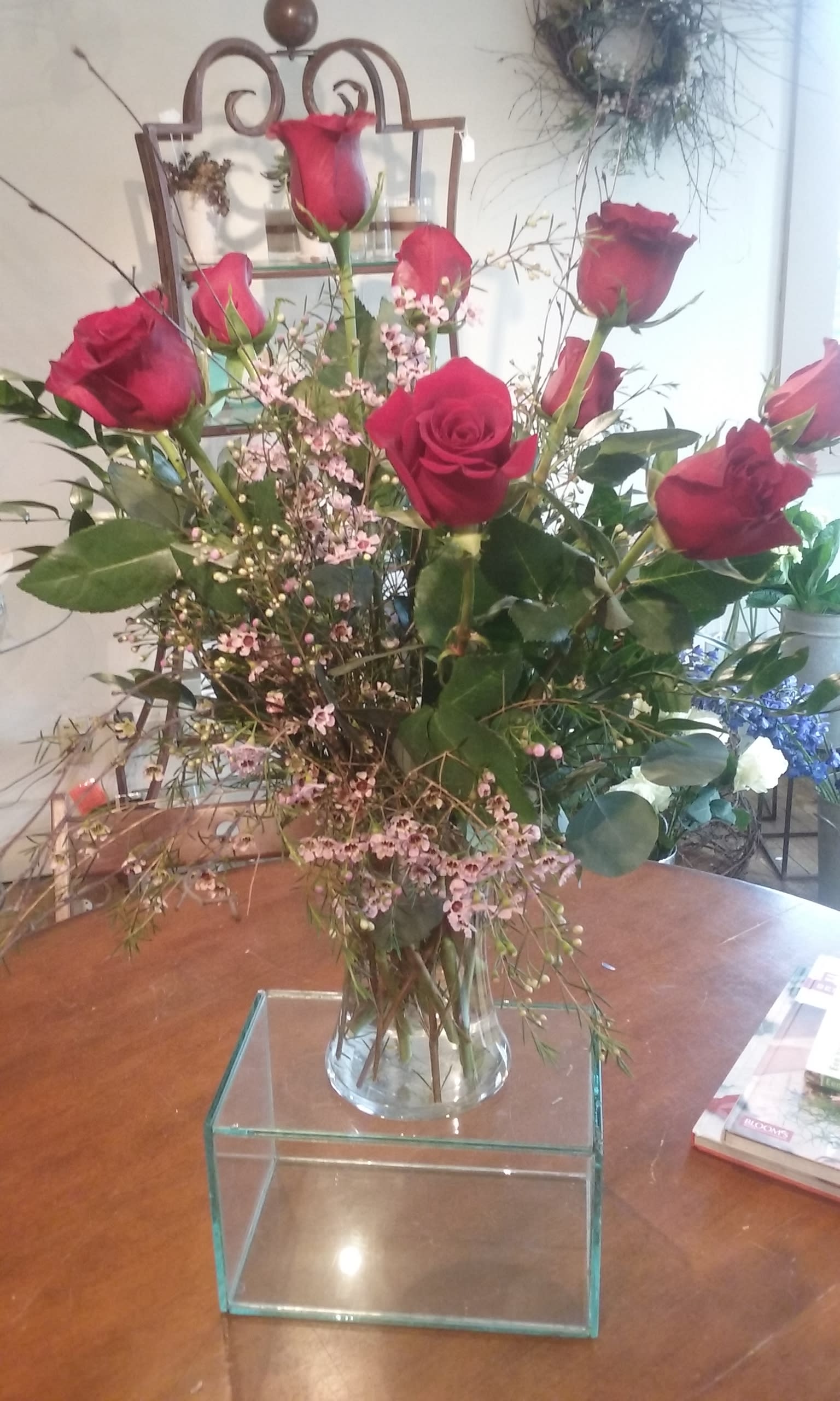 dozen roses in vase dozen roses in vase - a dozen eucuadorian roses in clear vase, with wax flower, greens and branches. red