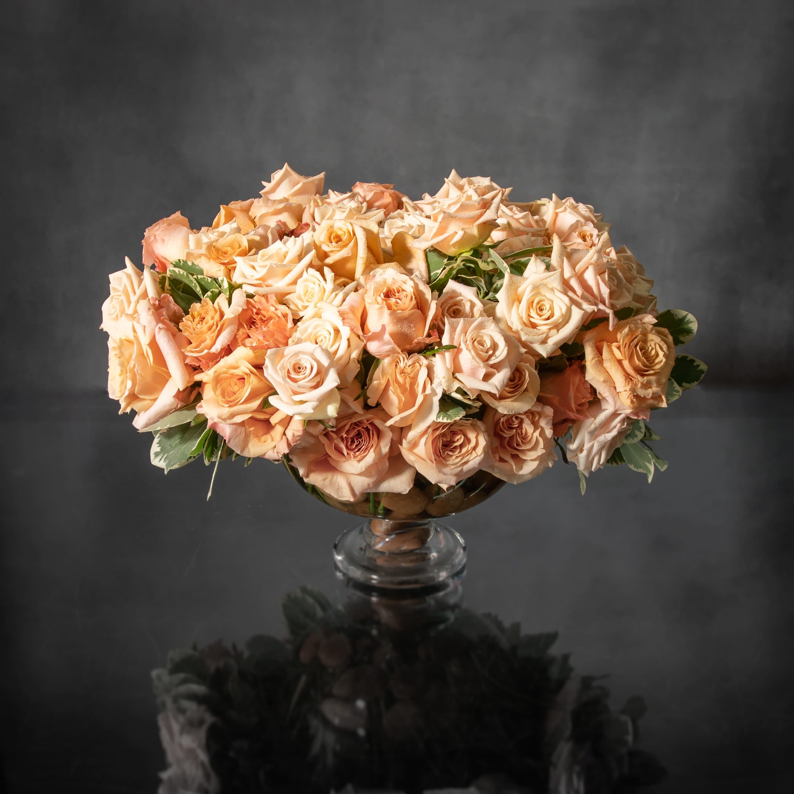 Peaches and Cream  - This timeless piece is a Classic beauty with hints of subtle colors. An arrangement with these soft tones can make the area it's in just peachy while adding a touch of romance.    The arrangement is grounded in an 12&quot; Glass Pedestal Vase. Approx. 80 stems Roses 