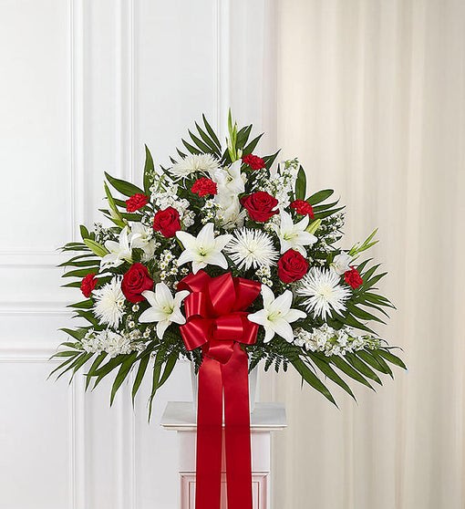 Red and White Standing Basket - Love can help keep us going after a difficult loss. Sometimes this emotion is best expressed through a beautiful floral statement. Handcrafted by our expert florists, our majestic standing basket arrangement is filled with an array of radiant red and pure white blooms and offers heartfelt condolences when words alone aren’t enough.