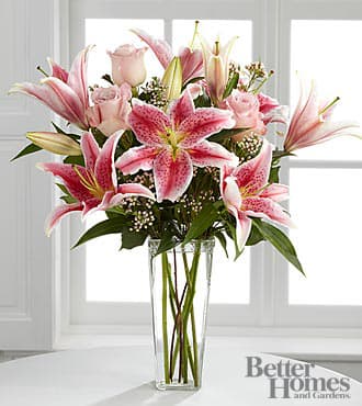 The FTD® Simple Perfection® Bouquet by Better Homes and Gardens® - B25-4390S  FTD® presents the Better Homes and Gardens® Simple Perfection™ Bouquet. Speak from your heart to theirs with a collection of pink vibrant blooms. Pale pink roses collaborate with the magic of Stargazer Lilies, displaying their fragrant fuchsia petals amidst waxflower accents. Beautifully arranged in a clear square tapered glass vase, this bouquet sends your warmest sentiments with glamour and grace. GOOD bouquet is approximately 20&quot;H x 14&quot;W.  Lilies may arrive in various stages of development. The lily blooms will continue to open, extending arrangement life - and your recipient's enjoyment.
