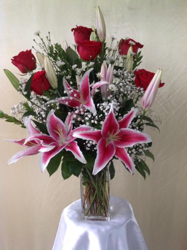 Love is on the air by everbloom - 6 premium Red roses with stargazer lilies arranged in a glass vase with greenery, gypsophilia.  hand delivered for our driver to the step door of your belove one.