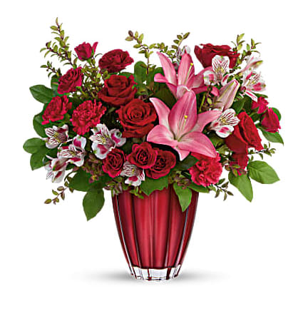 Teleflora's Romantic Radiance Bouquet - Shimmering with a metallic ombre finish and bursting with a lavish bouquet of classic red roses and pink lilies, this unique European glass vase is a Valentine's Day gift they'll cherish forever. This arrangement includes red roses, dark pink spray roses, pink asiatic lilies, light pink alstroemeria, hot pink carnations, red huckleberry and lemon leaf. Delivered in Teleflora's Sophisticated Love vase. Orientation: All-Around 
