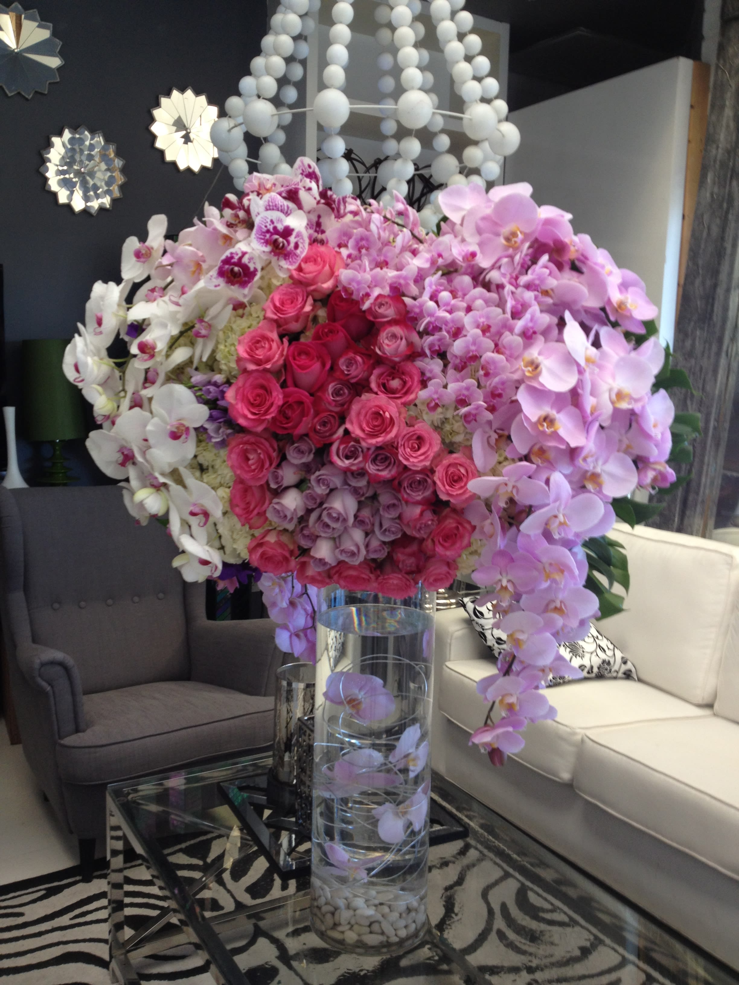 Pretty Woman - One of our most impressive arrangements! With cascading phalaenopsis orchids, roses, and hydrangea, this huge piece--sitting atop a tall cylinder vase with submerged orchids--will make the grandest of gestures, or statements for any space or person! 