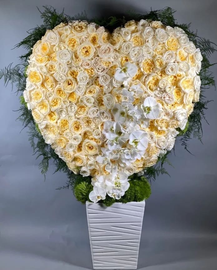 Pure Heart - This giant heart is full of buttercream and white roses and accented with luxurious white phalaenopsis orchids. A great statement piece for your loved one!