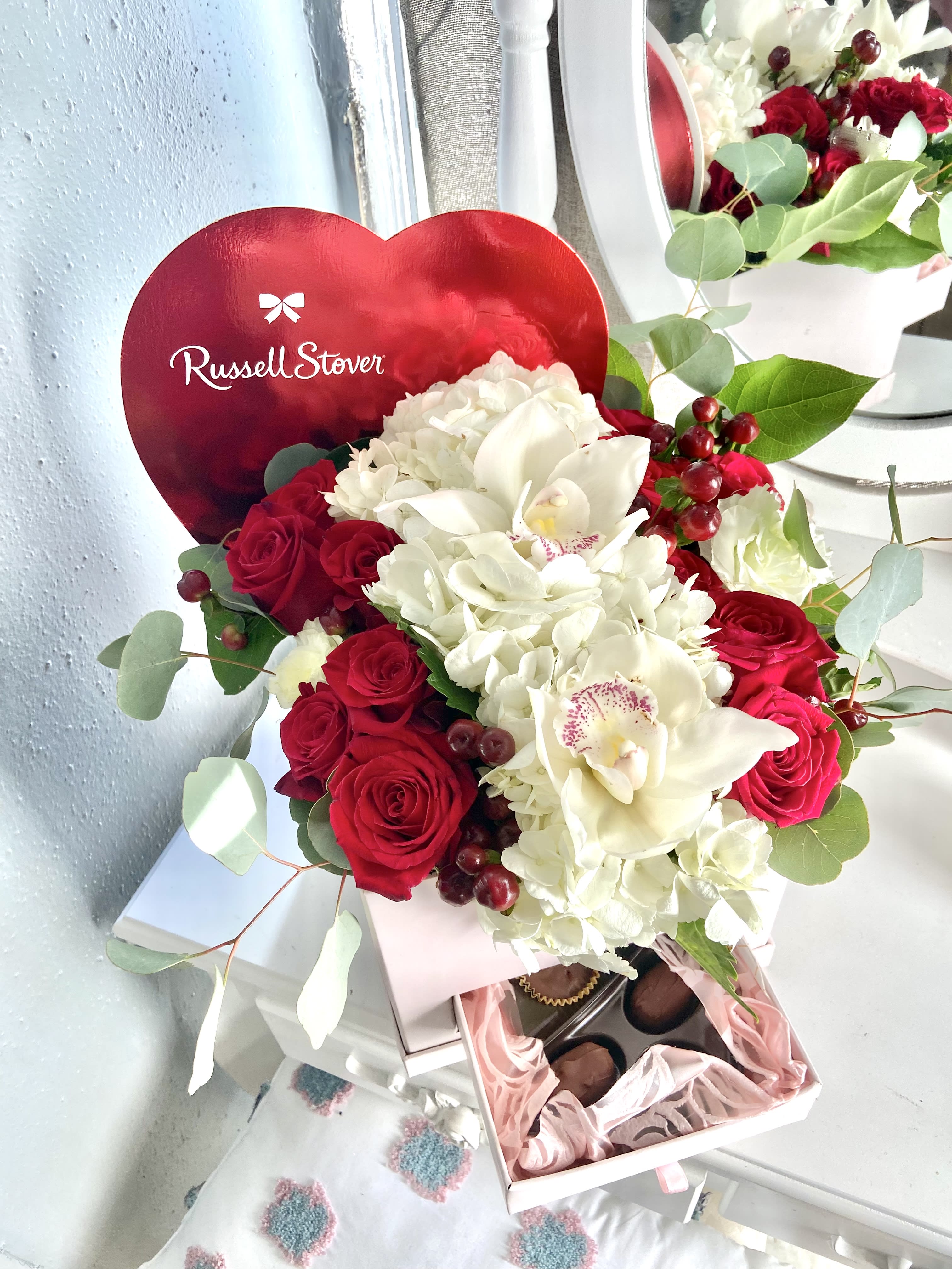 Russell Stover Romantic Box - Give this romantic box to your loved one filled of Russell stover chocolates, hydrangeas , red roses and a touch of silver eucalyptus 