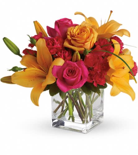 Teleflora's Uniquely Chic - Uniquely beautiful and uniquely bright this is a bona fide bombshell of a bouquet. Brilliant blossoms are perfectly arranged in an exclusive cube vase. Orange roses hot pink roses spray roses and carnations are joined by glowing orange asiatic lilies and bear grass in a delightful vase. This unique arrangement is delivered in a cube but it's definitely not for squares.Approximately 13&quot; W x 11 1/2&quot; H Orientation: All-Around As Shown : T47-3ADeluxe : T47-3BPremium : T47-3C