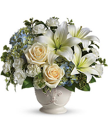 Beautiful Dreams - Soothing and respectful. Calm and compassionate. This beautiful collection of white and light colored blossoms will deliver your loving thoughts perfectly.  Tasteful flowers such as light blue hydrangea, crème roses, white asiatic lilies, miniature carnations and more are delivered in a lovely white French Country Pot.  Approximately 13&quot; W x 12&quot; H