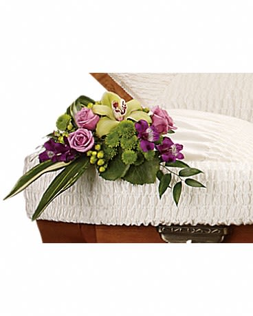  Dearest One Casket Insert - A stunning bouquet featuring lavender roses and a green orchid placed inside the casket is a tender and very personal tribute.  The radiant arrangement includes one green cymbidium orchid, lavender roses, purple alstroemeria, green button spray chrysanthemums and green hypericum, accented with assorted greenery.
