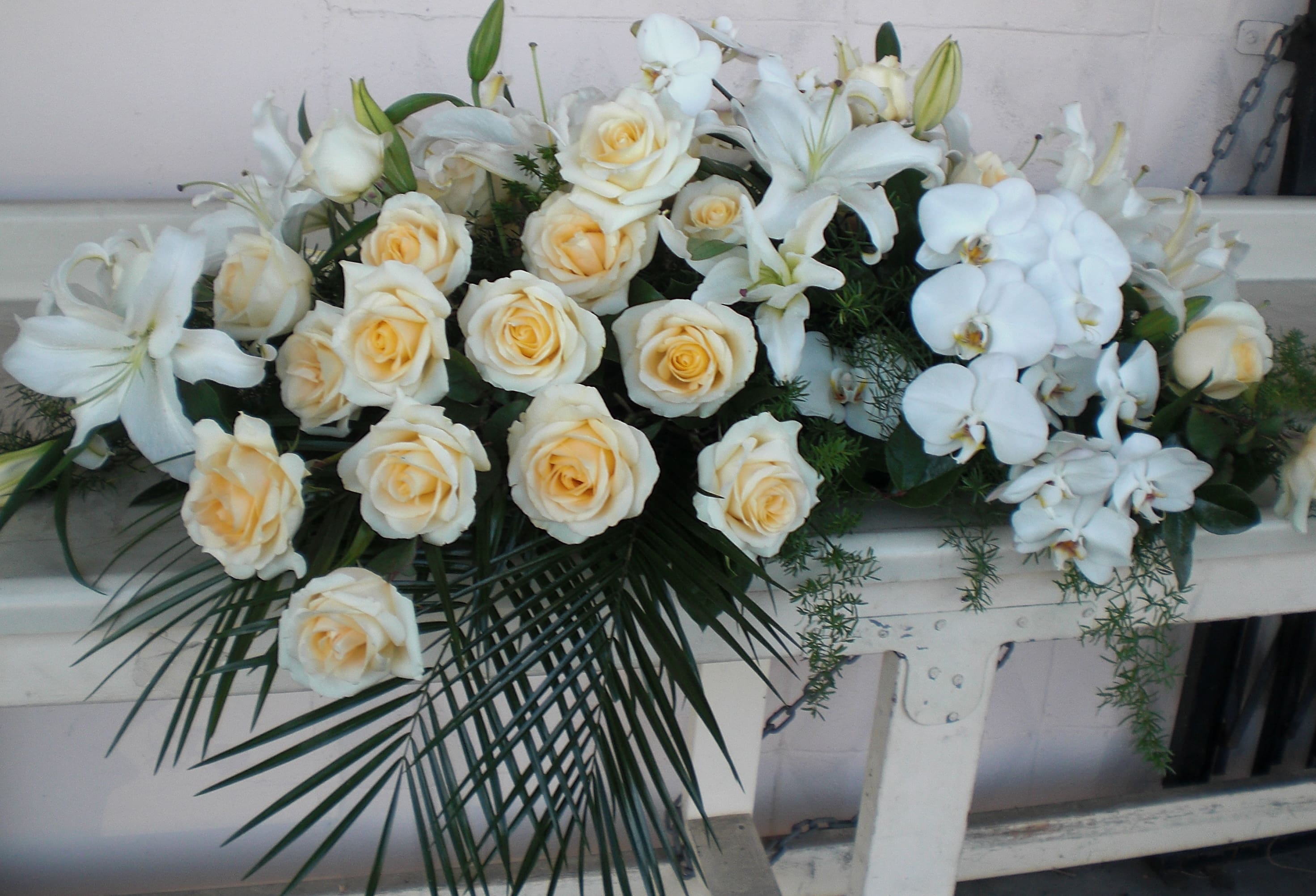 Serenity spray -  Serene, softly colored roses and orchids spray . Beautiful foliage  is threaded throughout to complement the soft look.