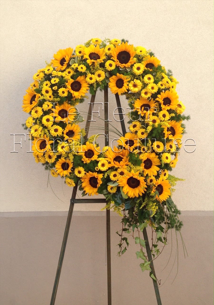 Radiant Sun Wreath - A bright and sunny Sunflower wreath complimented with viking daisies, solidago, ivy, bear grass and mink fern.