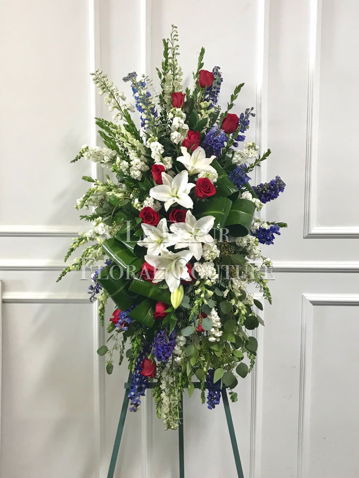 Patriot Salute - A beautiful standing spray with a modern design consisting of red, white and blue flowers to honor a true patriot. 