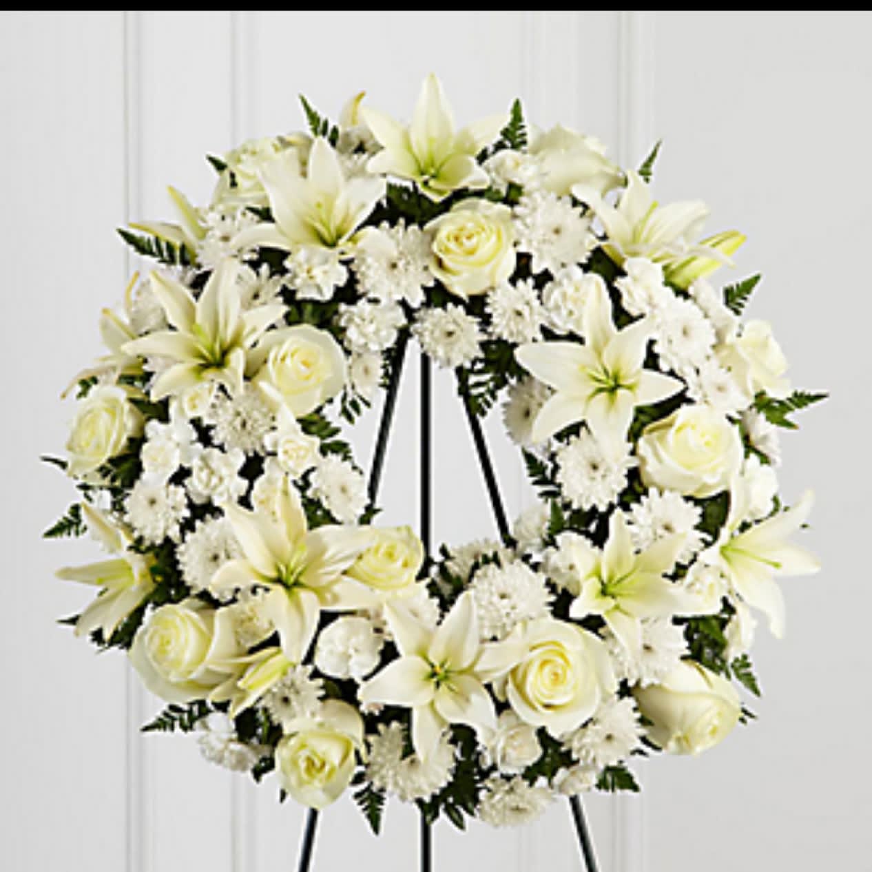 Treasured tribute wreath - White roses white Asiatic lilies white cushion poms white mini carnations  (shown 15'-18&quot; wreath) 24&quot; Wreath is $250.