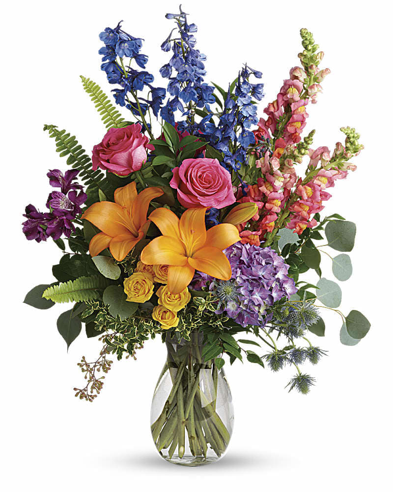 Colors Of The Rainbow Bouquet - Color any occasion beautiful with this lovely bouquet of hydrangea roses and lilies in all the colors of the rainbow. This colorful bouquet includes purple hydrangea pink roses yellow spray roses orange asiatic lilies purple alstroemeria blue delphinium pink snapdragons blue eryngium huckleberry oregonia Israeli ruscus sword fern silver dollar eucalyptus seeded eucalyptus and lemon leaf. Delivered in a jordan vase.