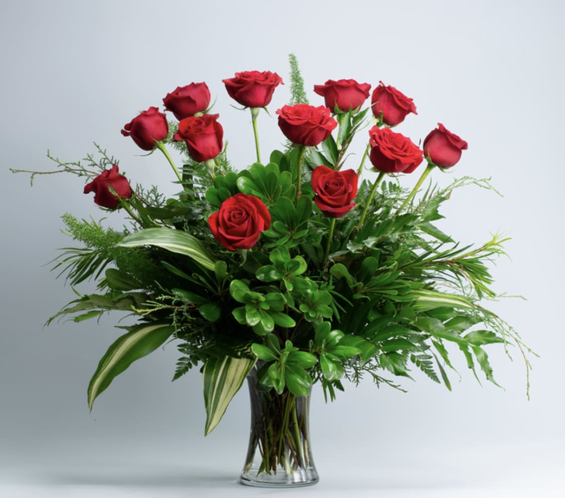 Flawless Roses - The most universally loved flower in a classic presentation. A dozen long-stemmed roses is accented with vibrant seasonal foliage in an elegant glass vase. 