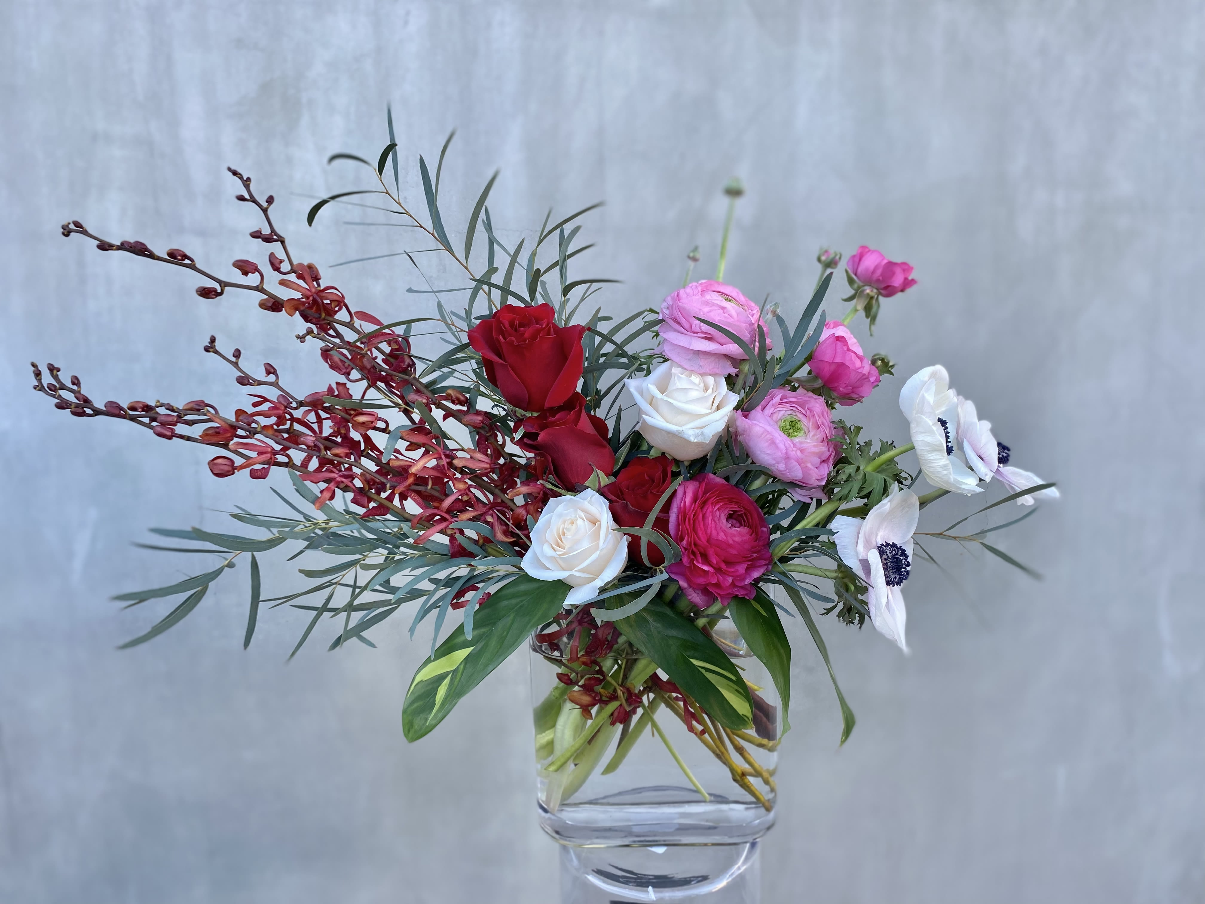 Sweet and Spicy Sweet and Spicy - This eye-catching arrangement contains roses, ranunculus, anemones, orchids, and greenery.