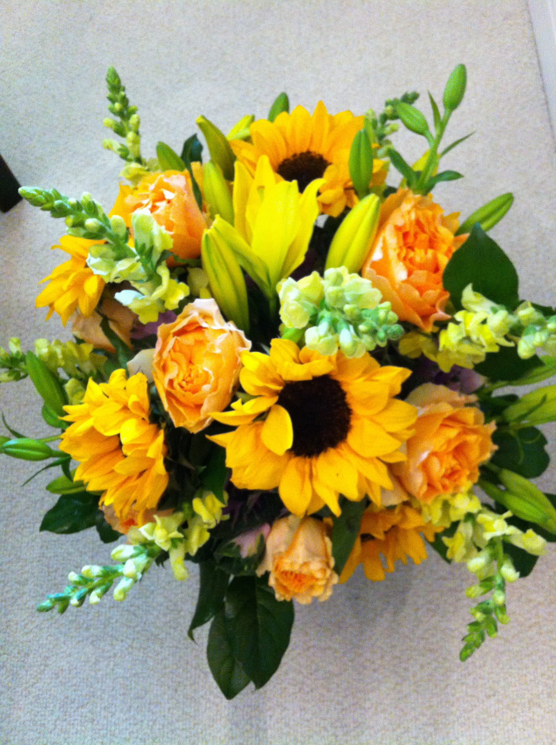 Burst of Sunshine Burst of Sunshine - A bright yellow burst of flowers arranged in a clear glass vase, a low full design. Individual varieties will vary according to seasonality.