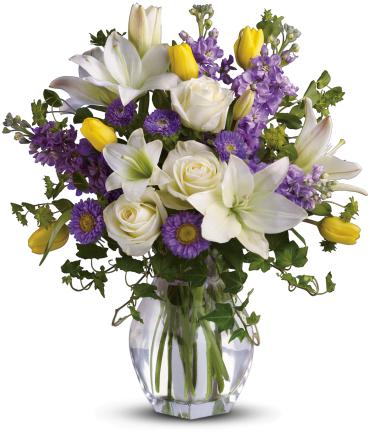 Spring Waltz - Dance into spring! Send this feminine bouquet of favorite spring flowers to brighten someone's home with the playful beauty of nature. Such a pretty way to say, &quot;I'm thinking of you!&quot;  This white, lavender and yellow bouquet includes white asiatic lilies, cream roses, yellow tulips, lavender stock, lavender matsumoto asters and greens including bupleurum, ivy and seeded eucalyptus. Delivered in a gorgeous reception vase. 